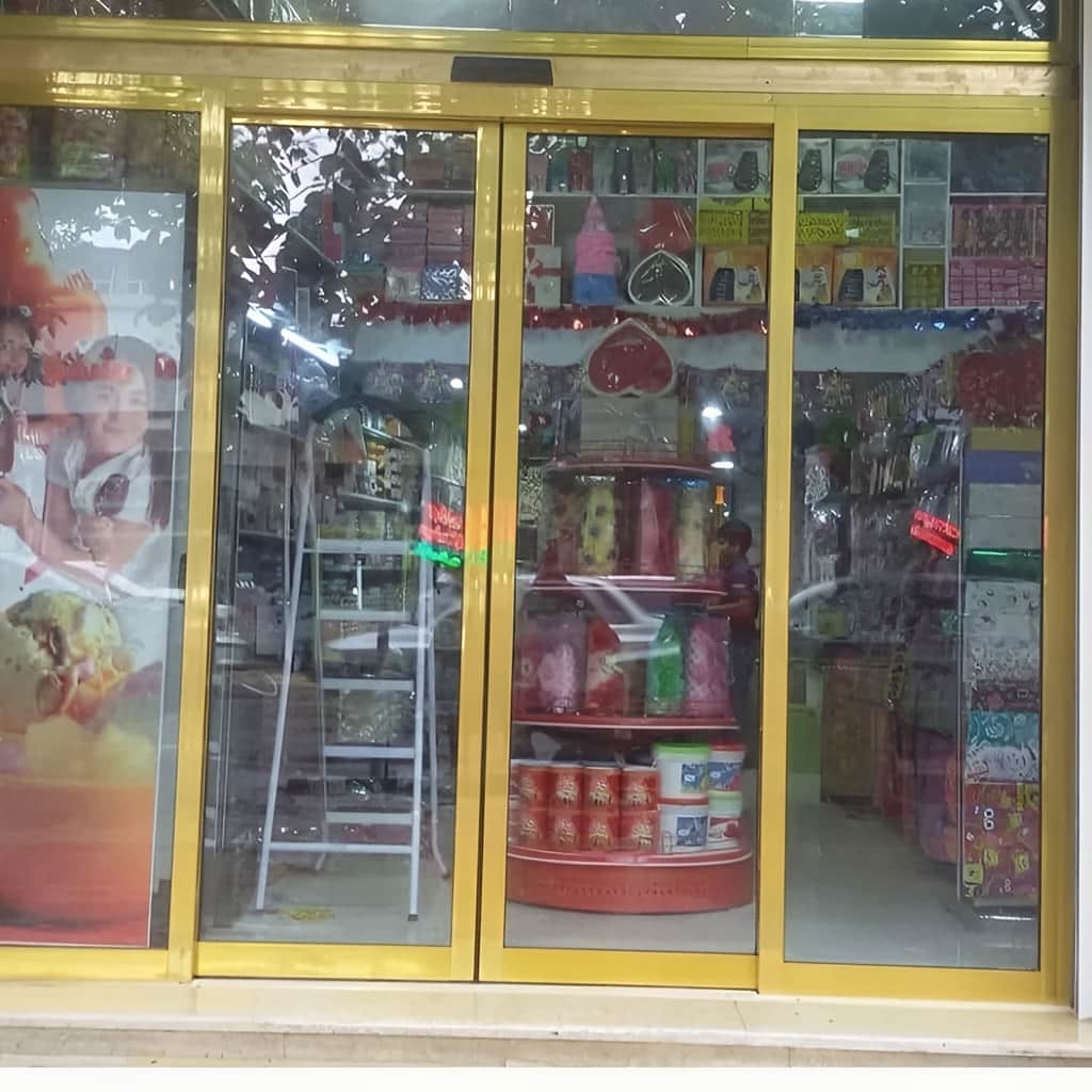 درب اتوماتیک شیشه ای دو لنگه کشویی فریم لس برای نمای شفاف